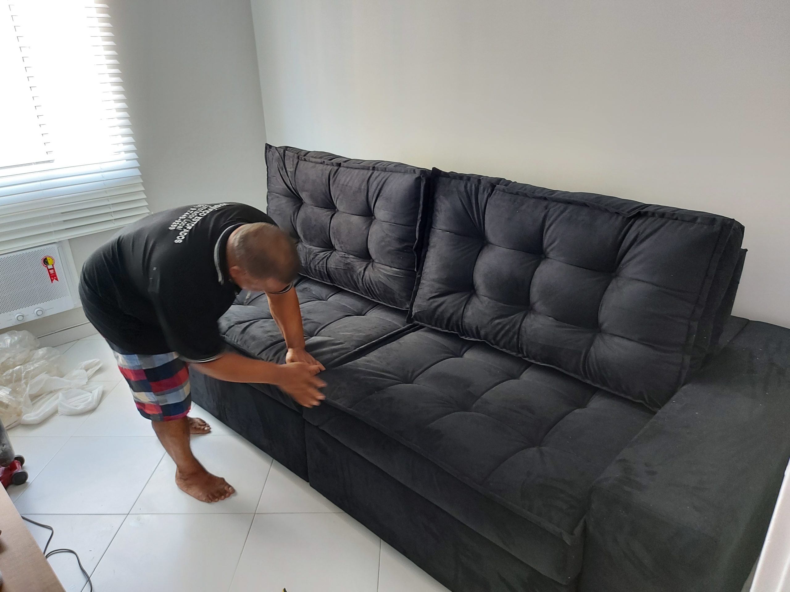 estofador-na-taquara-rj-realizando-costura-em-sofa-de-veludo-preto-com-botoes-capitone-jacarepagua