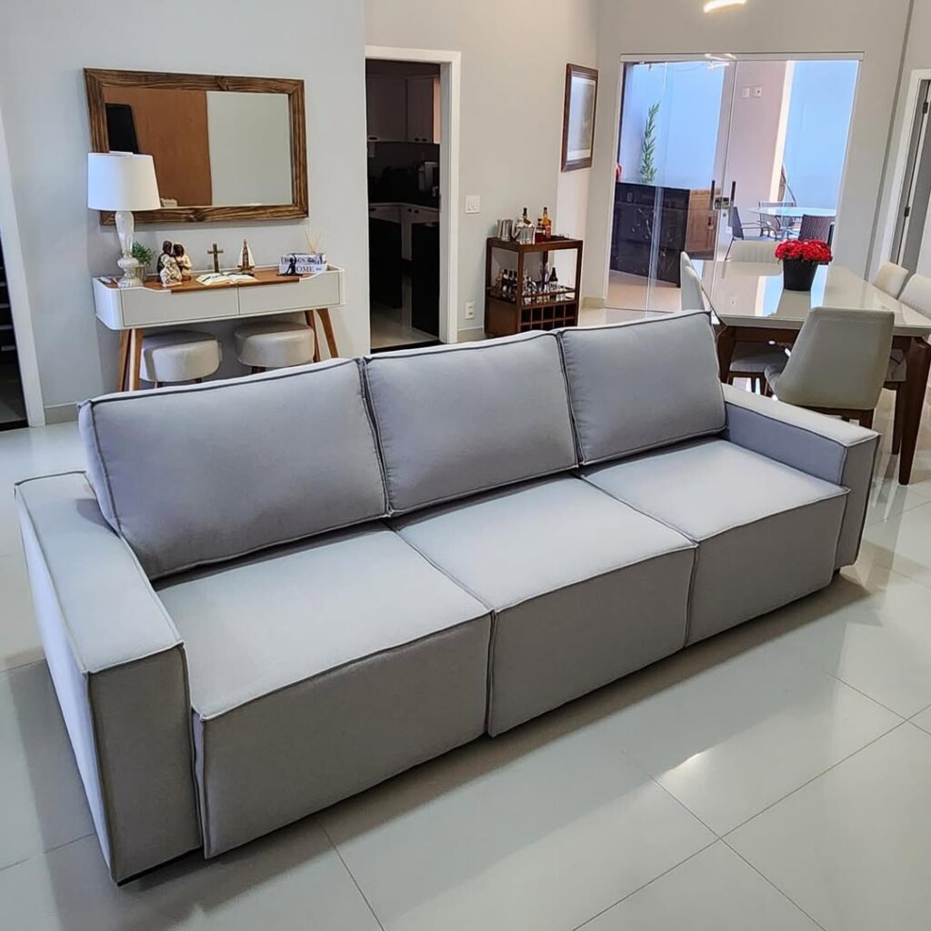 Reforma de sofá de 3 lugares em linho cinza com acabamento de alto padrão no Recreio dos Bandeirantes pela Magnífico Upholstery.