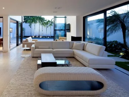 Sofá de canto branco em linho de alta qualidade em uma sala de estar moderna e luxuosa com vista para o mar na Barra da Tijuca, Rio de Janeiro. Exemplo de reforma de estofados de luxo.